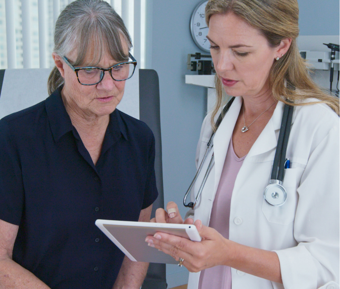 female primary care physician having conversation with older caucasian woman during regular check up