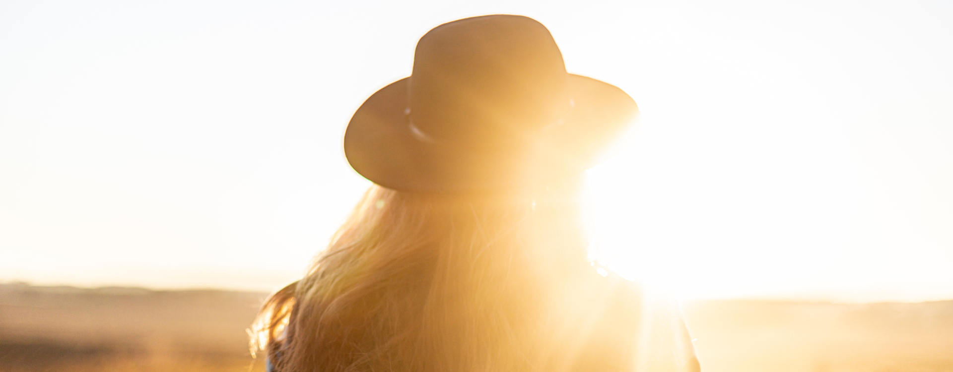 woman wearing a wide brimmed hat in the fall sun