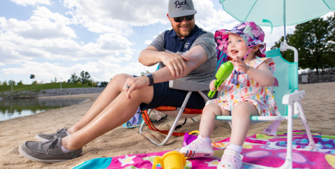 parent and toddler on beach with sunscreen