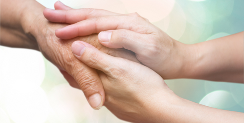 a caregiver holding a person's hand